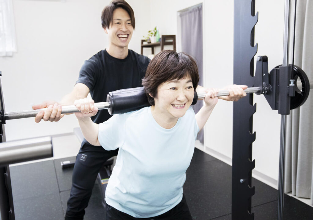 トレーニングをする笑顔の女性と笑顔のトレーナー